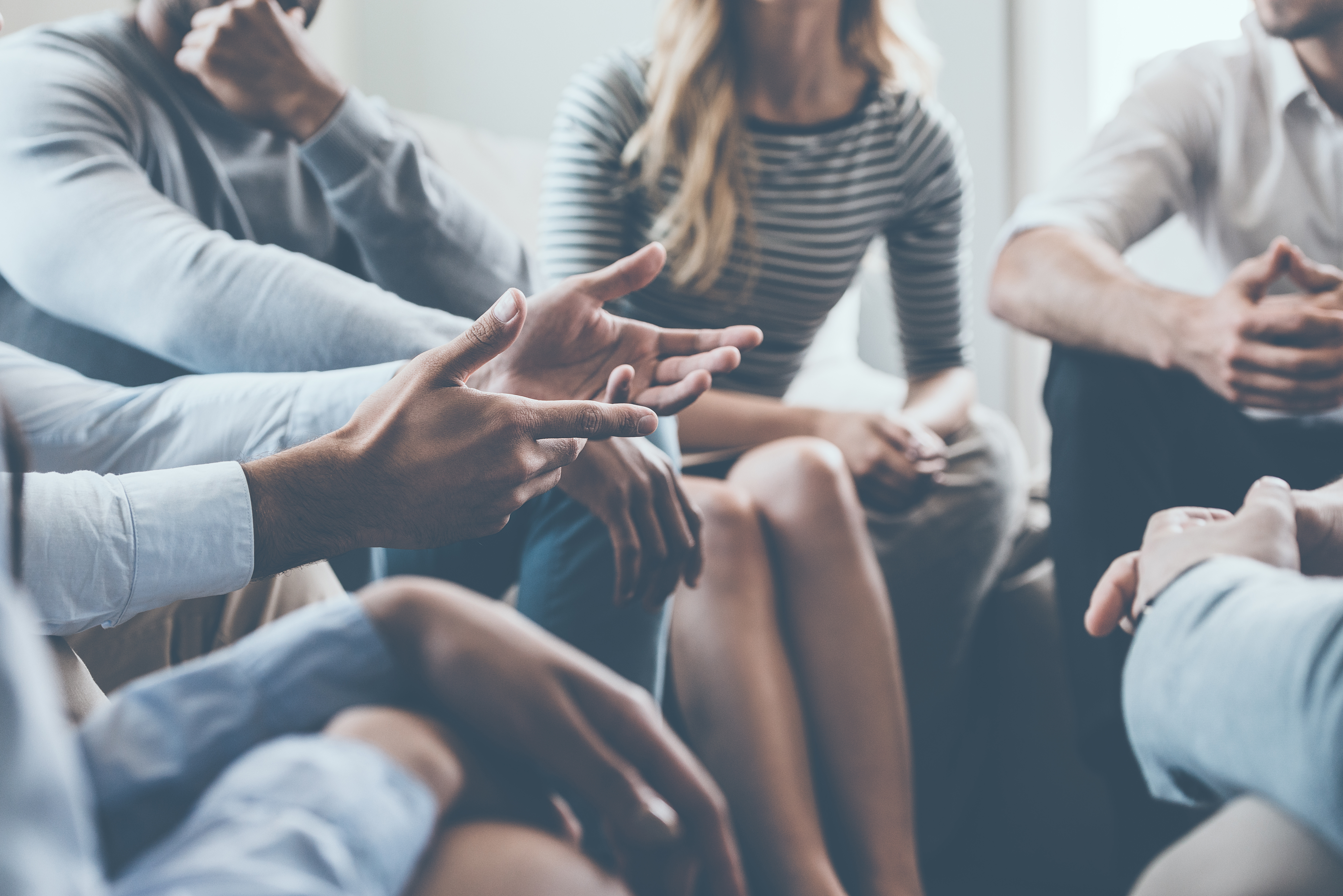 Close-up on discussion. Close-up of people communicating while sitting in circle and gesturing